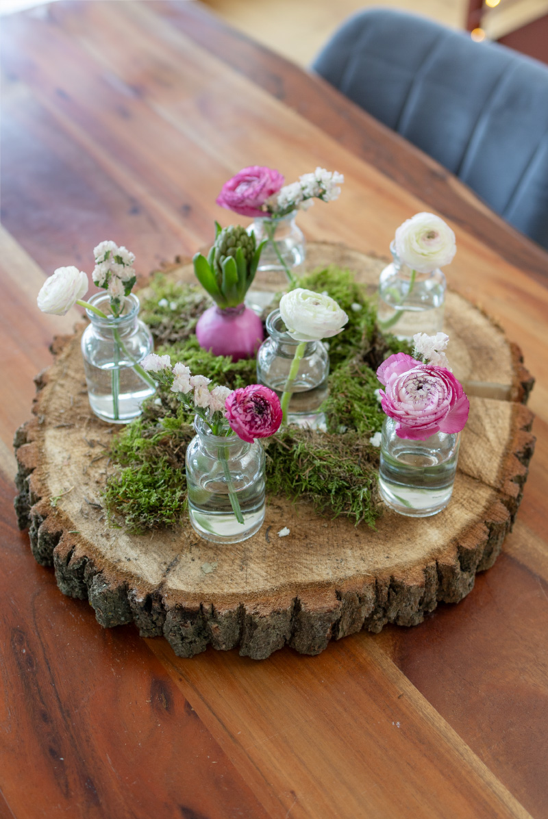 Frühlingstischdeko mit Blumen und Naturmaterialien